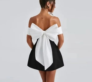 Detailed back view of a black strapless dress with a large white contrast bow feature