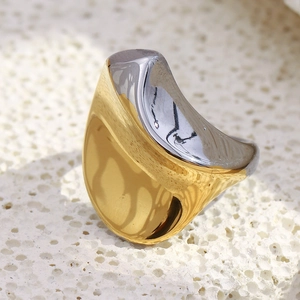 Gros plan sur une bague torsadée bicolore en acier plaqué or 18 carats sur pierre blanche