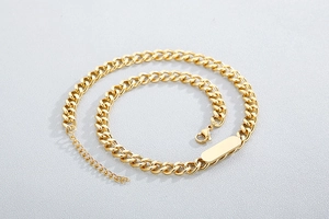Detailed view of golden Cuban chain bracelet with rectangle plate and lobster clasp