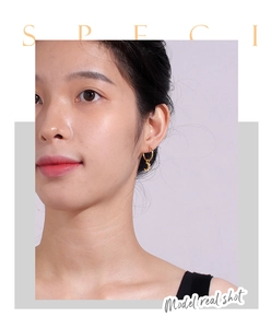 Close-up of gold-plated hollow moon earrings with zircon crystals on a model's ear