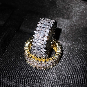 Close-up of gold and silver rings with pavé-set rectangular cubic zirconia stones