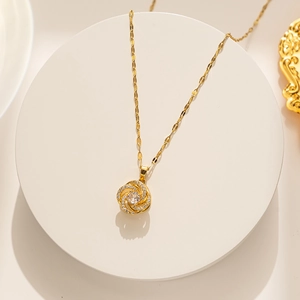 Macro detail of golden camellia flower pendant with sparkling zircon and center stone