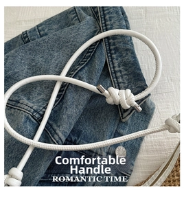 Detail of white woven rope handle with silver hardware on a straw tote bag