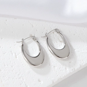 Macro shot of silver U-shaped earrings with a polished mirror finish on stone