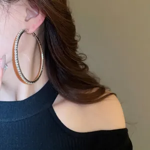 Boucles d'oreilles créoles argentées avec cristaux brillants sur un modèle élégant