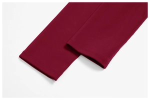 Macro detail of wine red yoga suit featuring reinforced double-needle stitching on cuffs