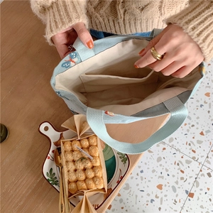 Détail intérieur d'un sac en toile bleue avec broderie papillon et petite poche interne