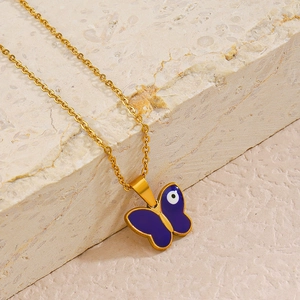 Blue evil eye butterfly necklace in gold stainless steel on a textured stone base