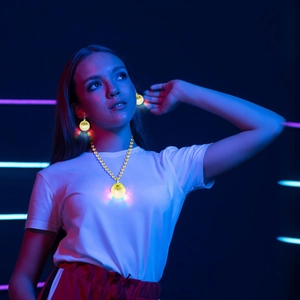 Close-up of glowing yellow disco ball necklace and earrings set for neon party