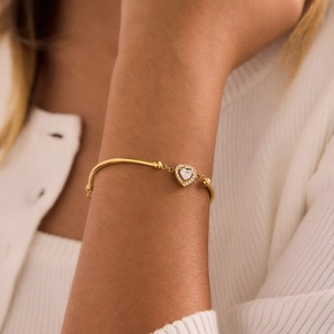 Close-up of 18K gold plated heart pendant bracelet with zircon stones on wrist