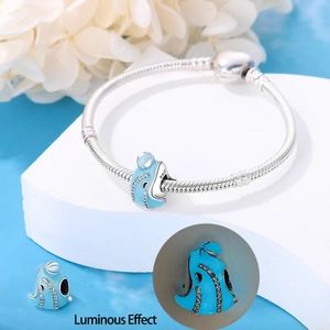 Luminous blue whale charm on silver snake chain bracelet with glowing night effect