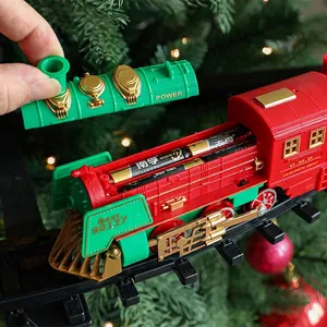 Vintage Christmas electric train toy set with red and green steam engine on tree tracks