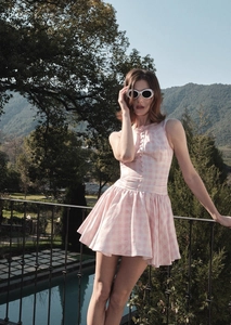 Close-up of pink and white plaid sleeveless dress with decorative front buttons