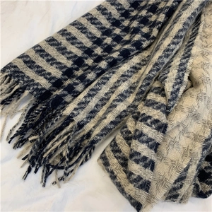 Detail of blue and white houndstooth scarf with elegant fringe tassels in soft wool blend