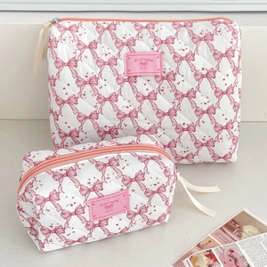 Close-up of quilted bow makeup bags with Good Night label and pink zipper detail