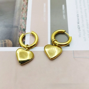 Close-up of golden heart earrings with Forever Love engraving and mirrored finish