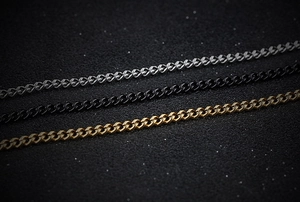 Detailed view of classic Cuban link chains in silver, black, and gold titanium steel colors