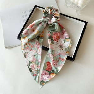 Detail of satin floral print scrunchie with long ribbons on a decorative tray