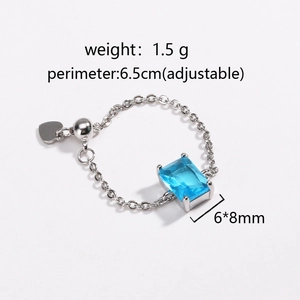 Detailed view of adjustable chain ring with blue emerald-cut zircon and heart charm