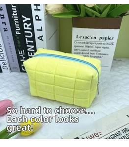 Detail of yellow quilted velvet pouch with contrast blue zipper for stationery or makeup