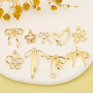 Nine piece set of 18K gold plated bow and heart charms for DIY jewelry making