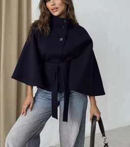 Detail of dark blue woolen cape coat showing the stand collar and button-up waist belt