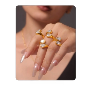 Detail of three gold rings with pear-cut zircon stones on model's hand and neck