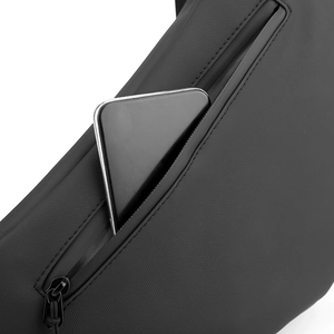 Close-up of waterproof black chest bag featuring a hidden zip pocket with a smartphone inside