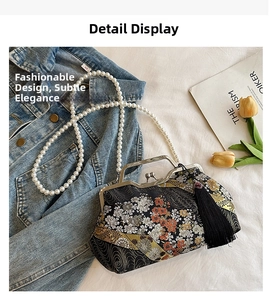 Detail of floral embroidery on black shell bag with silk tassel and pearl strap