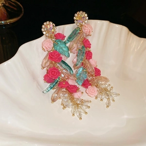 Detail shot of vintage style floral tassel earrings with pink roses and glass beads