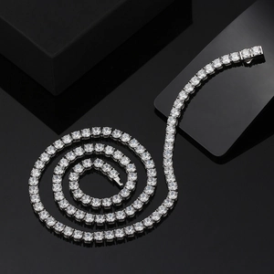 Macro shot of silver tennis chain with brilliant cut zircons on a reflective black background