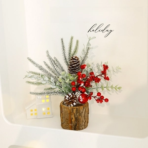 Mini Christmas tree with red berries, pine cones and frosted needles in a rustic wooden base