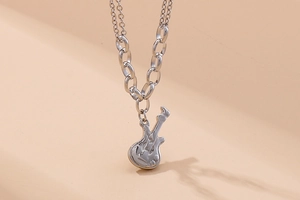 Detailed view of a silver violin pendant on a stylish double-layer stainless steel chain