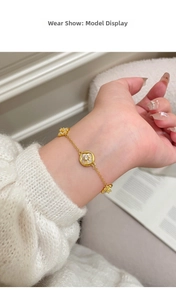 Dettaglio di un bracciale placcato oro 18K con ciondoli a fiore in madreperla e zircone