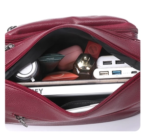 Internal view of large capacity crossbody bag showing multiple zipper compartments