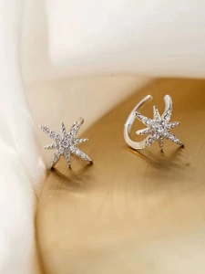 Macro shot of silver hexagram ear bone clip with white cubic zirconia on gold base