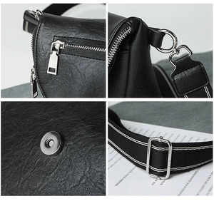 Detail view of black textured leather bag featuring metal zippers and adjustable fabric strap