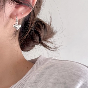 Close-up of minimalist S925 sterling silver heart-shaped drop earring on model ear