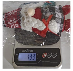 Detailed view of striped gnome Christmas plush weighing 139g in clear protective bag