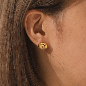 Detail of 18K gold stainless steel conch shell earring worn on model's ear