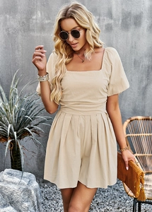 Detail showing square neck and puff sleeve of beige linen jumpsuit on a model