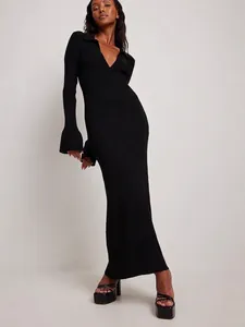 Slim fit black ribbed knit maxi dress with a deep V-neck and flared bell sleeves