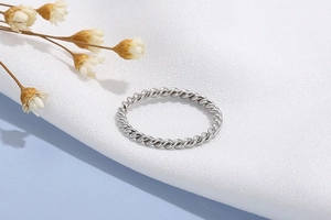 Detailed close-up of a silver twisted rope ring featuring a minimalist vintage metal texture