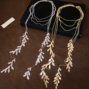 Detail of layered gold and silver leaf necklaces with hammer-textured metal finish