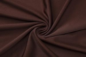 Macro shot of dark brown knitted fabric showing premium pleated texture and soft drape