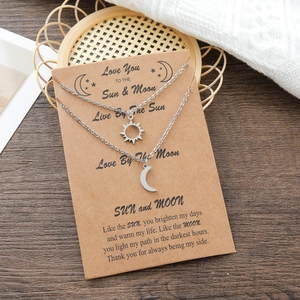 Detailed shot of silver sun and moon pendant necklaces on a vintage kraft card