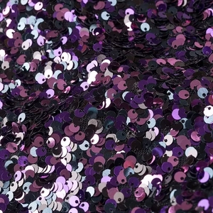 Macro shot of shimmering dark purple and violet round sequins on a party mini dress
