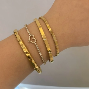 Vierteiliges Set aus goldfarbenen strukturierten Armbändern und Herz-Kristallketten