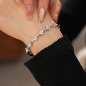 Close-up of elegant silver four-leaf clover bracelet with sparkling zircon stones