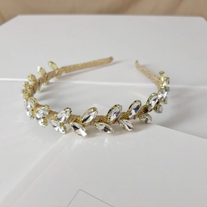 Detailed view of the gold laurel wreath headband with marquise rhinestones on a white card